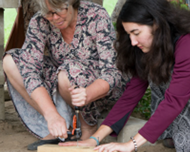 Amy and Mina '17 drilling a hole the old fashioned way.