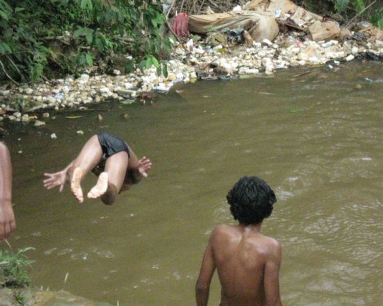 Watching children dive with great enthusiasm into a pool of brown water that is fed by a small stream and the effluent of many pit latrines.