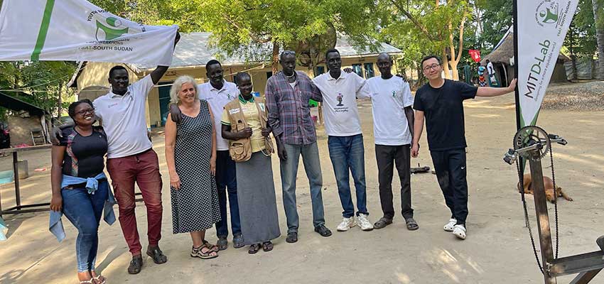 Nine adults standing in a line, posing for a picture.