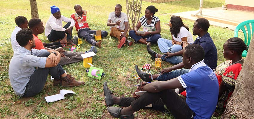 Group of people sitting on the grass talking.