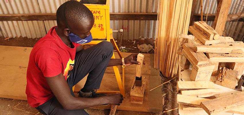 Young man with surgical mask building with metal and wood.